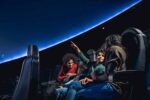 Family sat down in Life Science Centre's planetarium,.