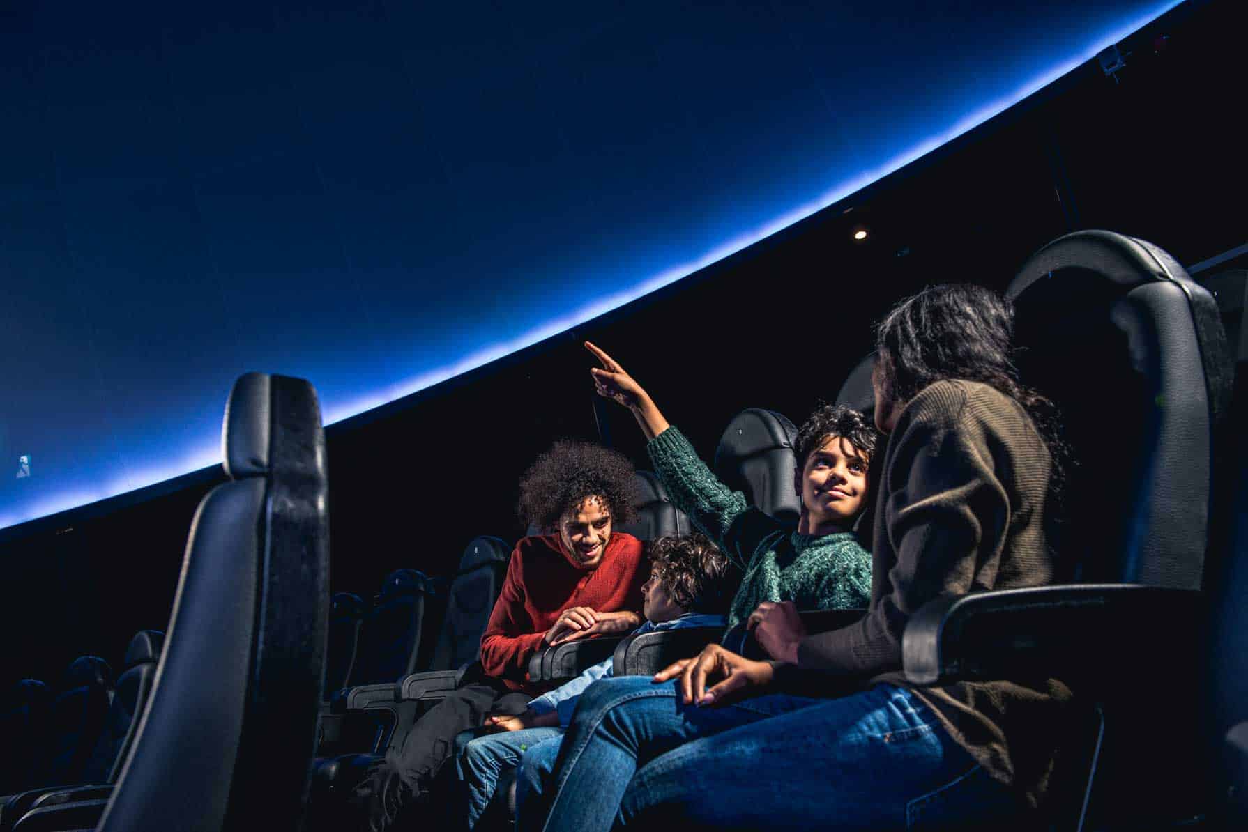 Family sat down in Life Science Centre's planetarium,.