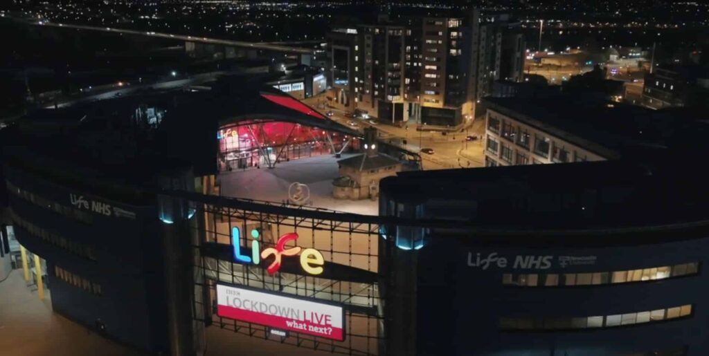 Overhead photo of The International Centre for Life, lit up on an evening.