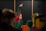 Boy with hand raised during Life Science Centre electricity workshop.