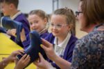 School Child Exploring Suitable Materials For Space Travel In An Education Workshop.