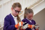 School children trying on gloves for space in education workshop.