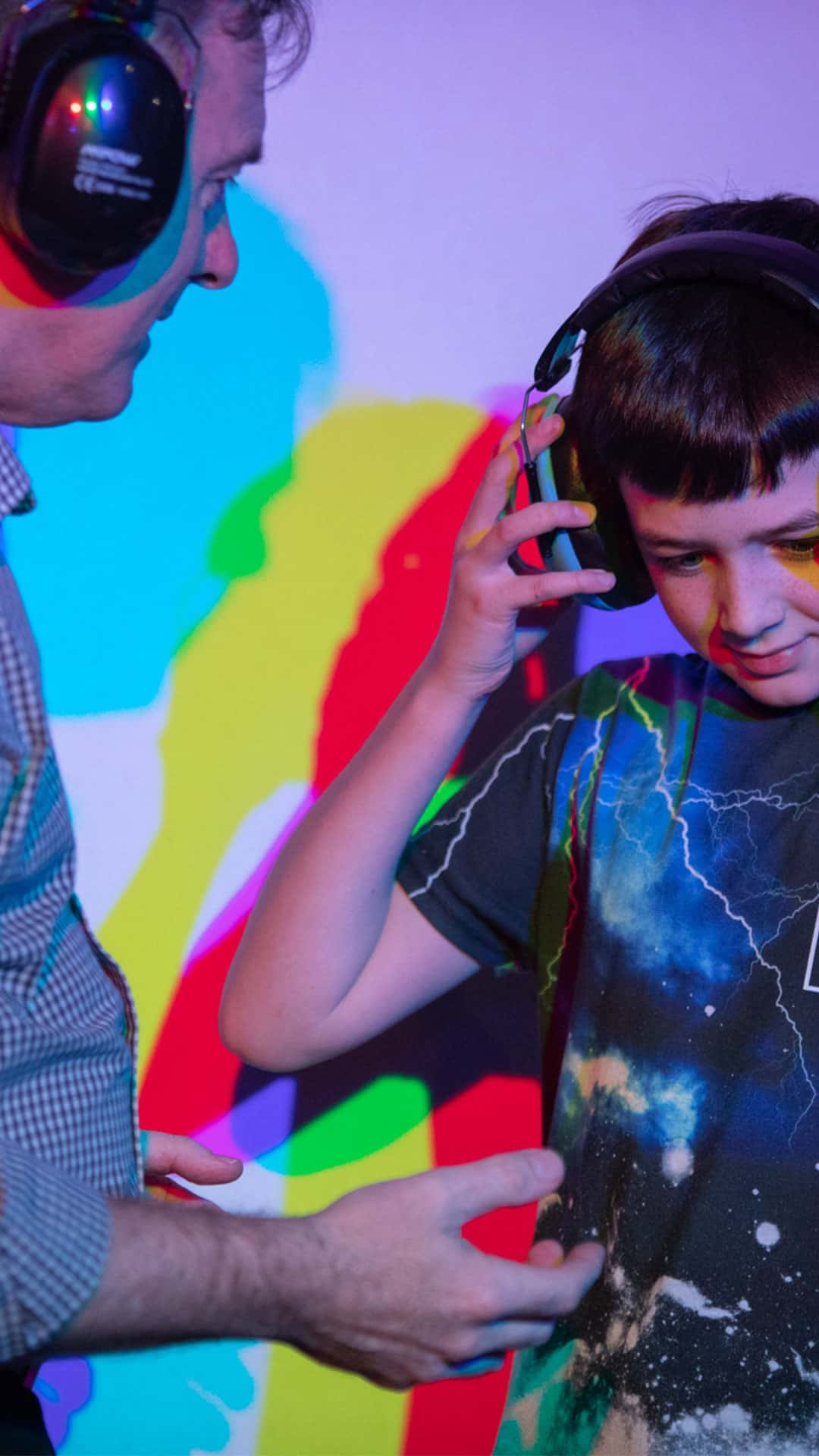 Young boy and adult man wearing ear defenders whilst on a day trip to Life Science Centre.