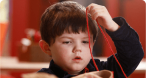 Little boy making a string portrait in The Making Studios at a Life Science Centre Birthday party.