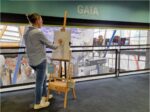 Older student using an easel to draw Planet Earth inside the science centre.