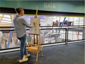 Older student using an easel to draw Planet Earth inside the science centre.