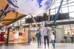 Family entering the science centre underneath Gaia, a large replica of Earth.