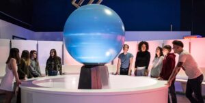 Group of visitors around Life's sphere, a circular dome in Space Zone