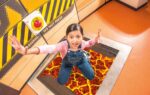 Young visitor enjoying Life Science Centre's trap door exhibit.
