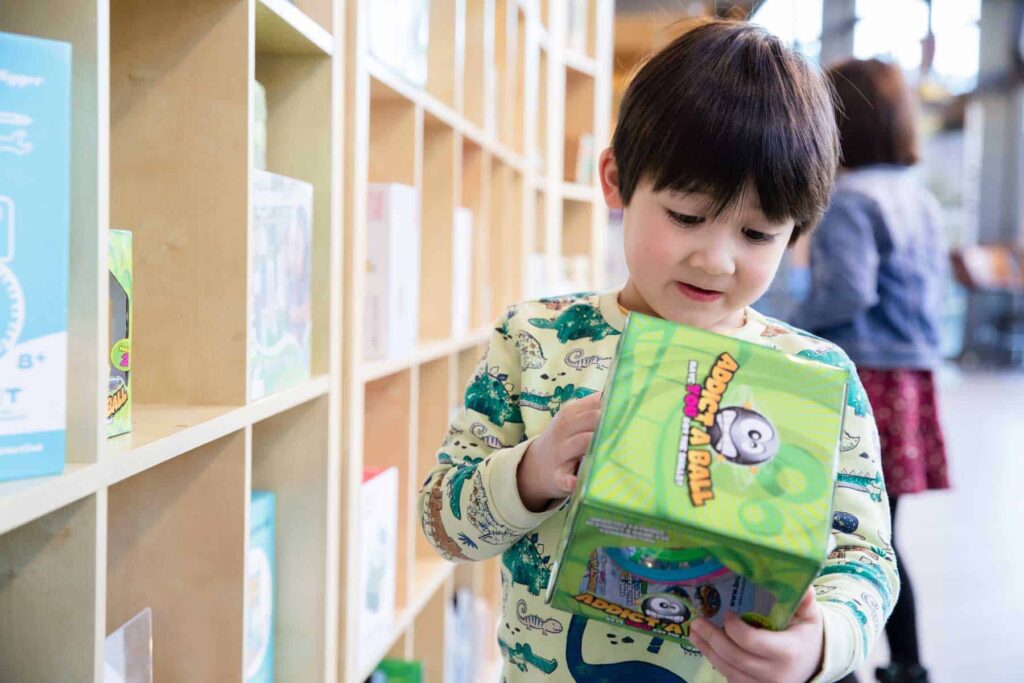 Young visitor looking at toy for sale in Life Science Centre's gift shop