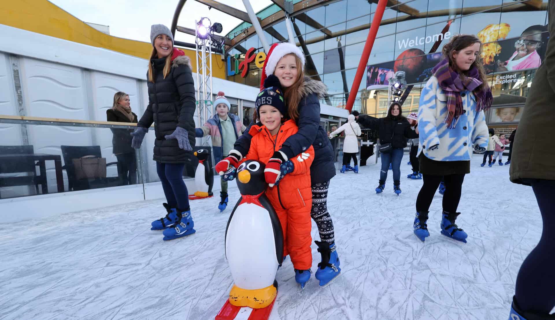 Brother and sister on Life's ice rink over the festive period with santa hats.