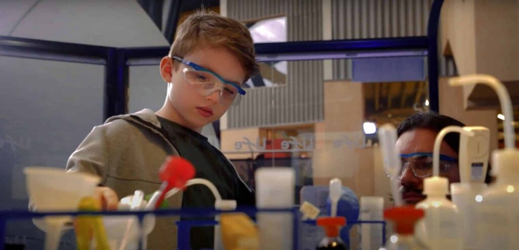 Young visitor wearing safety goggles whilst completing a science experiment at Life Science Centre.