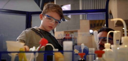 Young visitor wearing safety goggles whilst completing a science experiment at Life Science Centre.