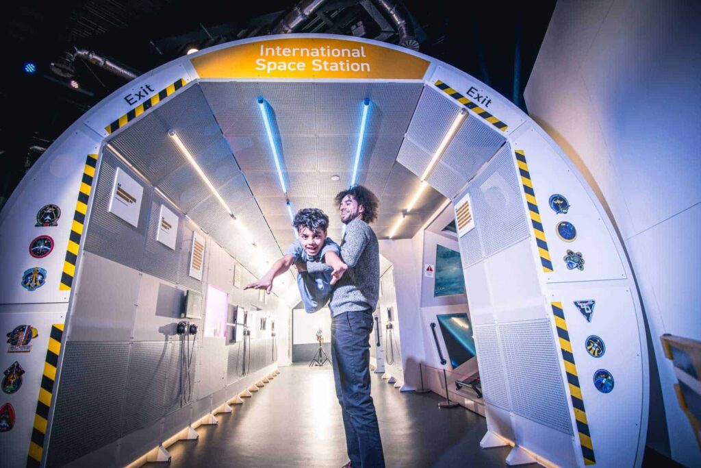 Father And Son At The Entrance To The Mock Up International Space Station.