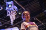 Girl Stood Underneath Astronaut Model With Her Face Projected Onto The Screen.