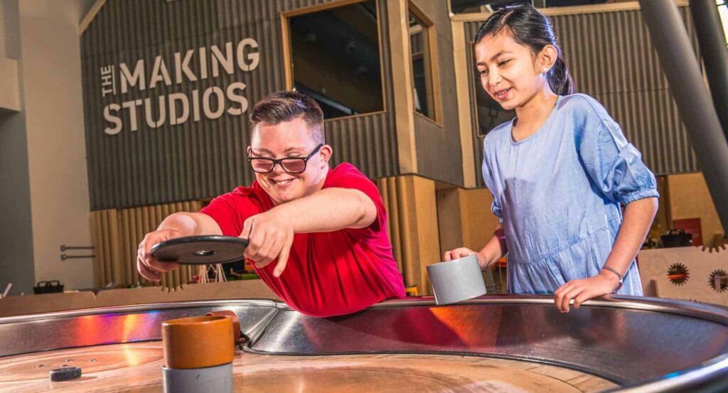 Two older childing enjoying Life Science Centre's spinning table.