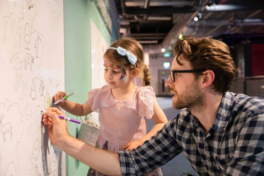 Father And Daughter enjoying the colour wall in Hello World