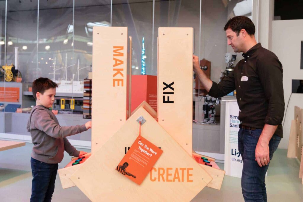Father And Son Using An Interactive Screen In Life Science Centre's Creativity Zone.