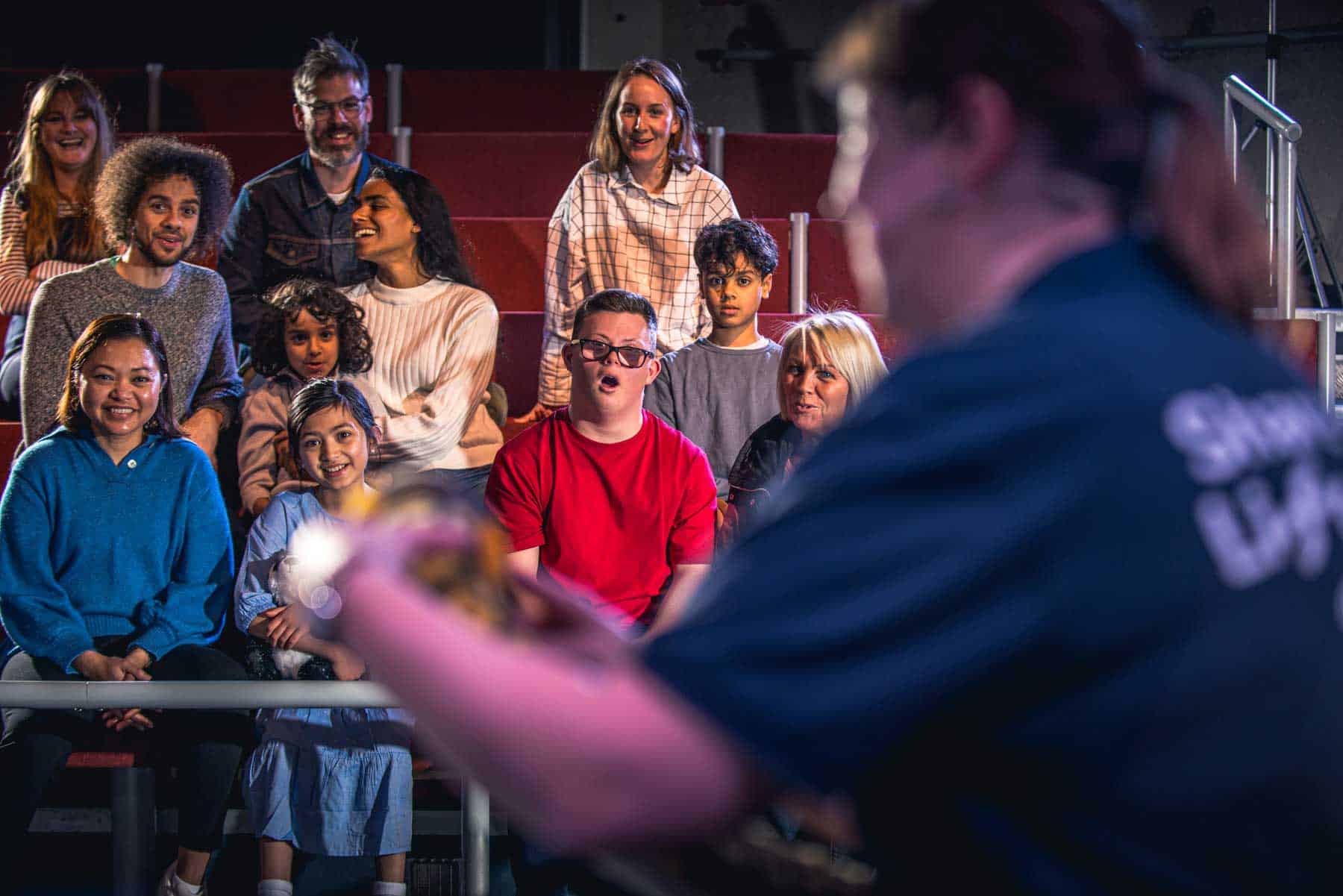 Group of science centre visitors watching a live science show headed up by an Explainer at Life Science Centre.