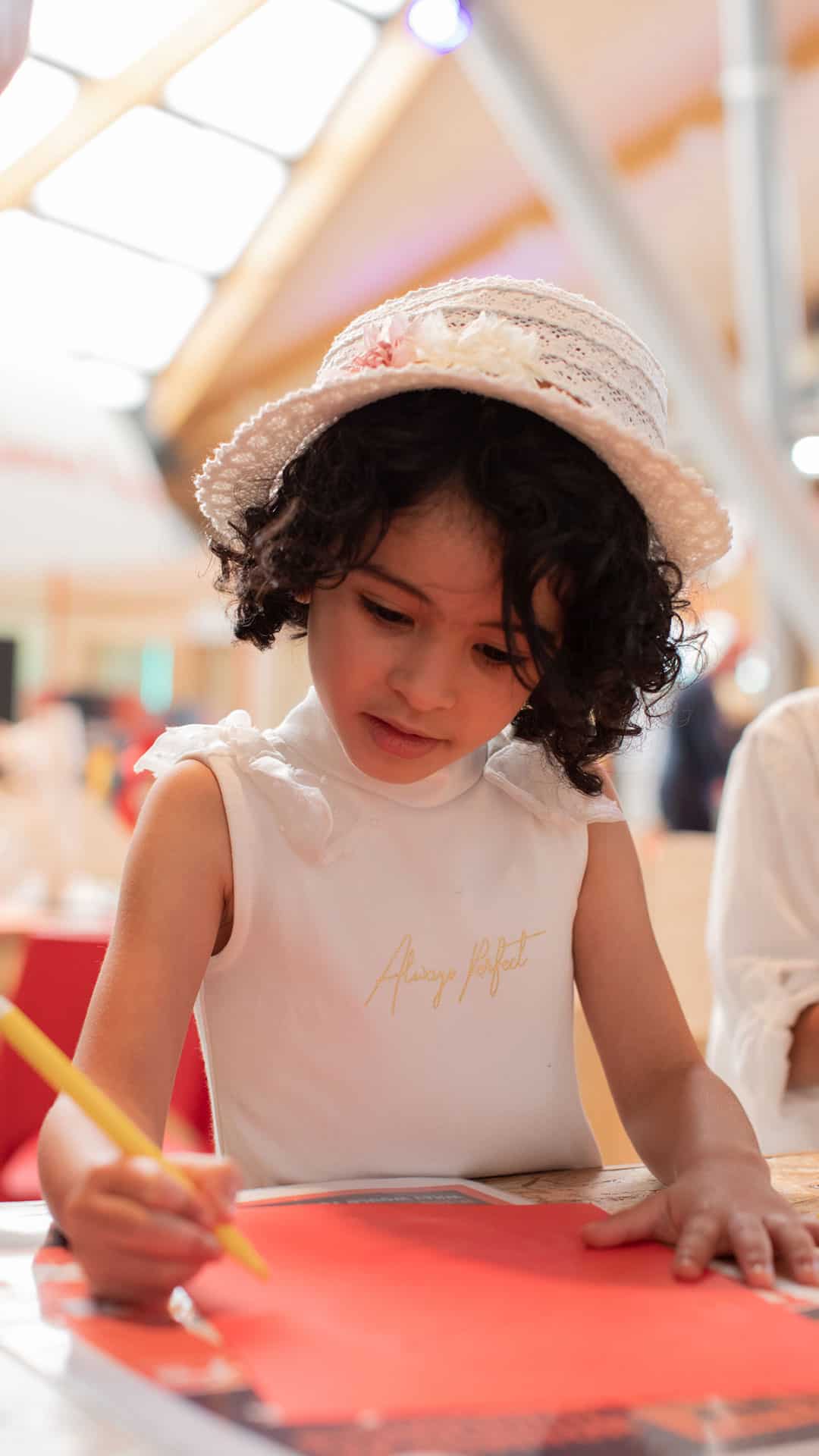 Little girl completing a craft activity with paper in The Making Studios
