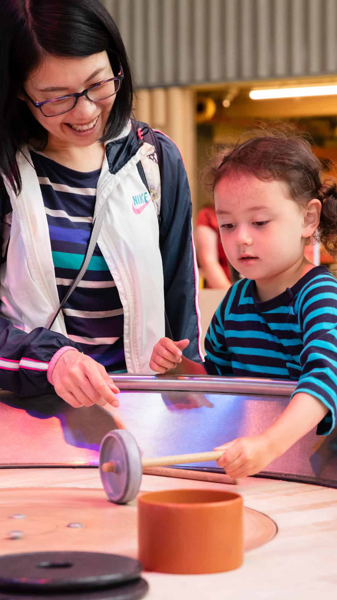 Mother and daughter playing with spinning table in Creativity Zone.
