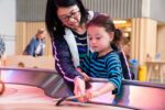 Mother and daughter playing with spinning table in Creativity Zone.