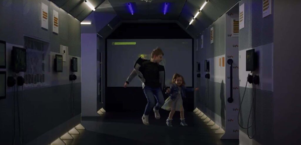 Two young children jumping in air in Life Science Centre's International Space Station model.