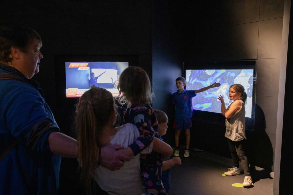 Two children presenting the weather inside Life Science Centre's mock-up weather studio