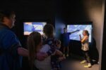 Two children presenting the weather inside Life Science Centre's mock-up weather studio