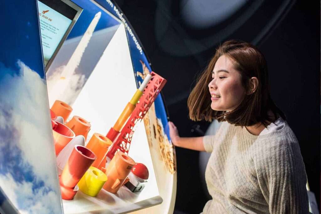 Woman Looking At Hands On Rocket Building Activity In Space Zone.