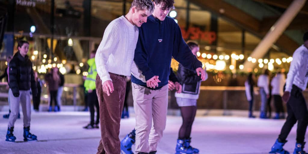 Young male couple enjoying an evening of Newcastle's outdoor ice rink.