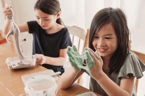 Young girl at home playing with homemade slime.