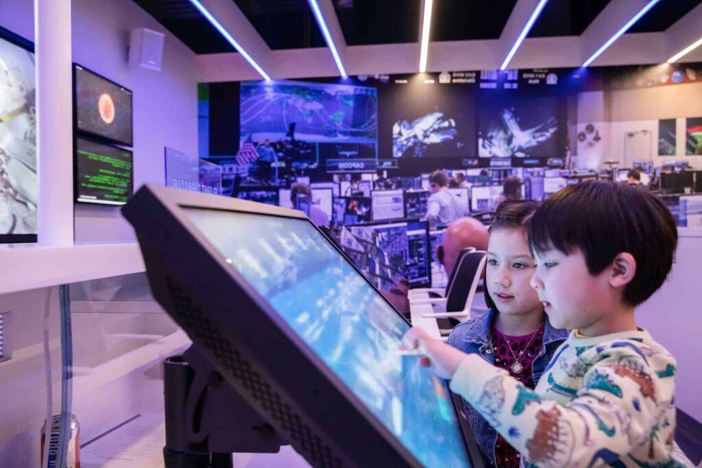 Two young visitors enjoying a hands-on space activity inside the science centre.