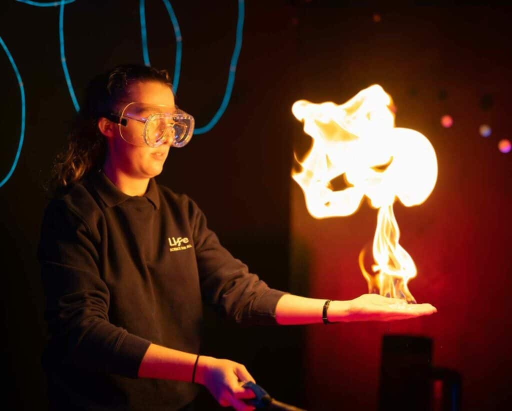 An explainer using flames in live science show inside Life Science Centre.