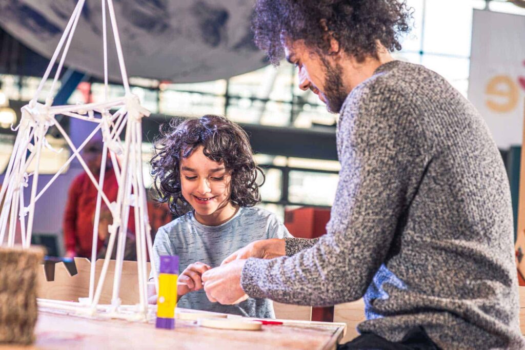 Father And Son making a sculpture using paper straws in Life Science Centre's Making Studios.