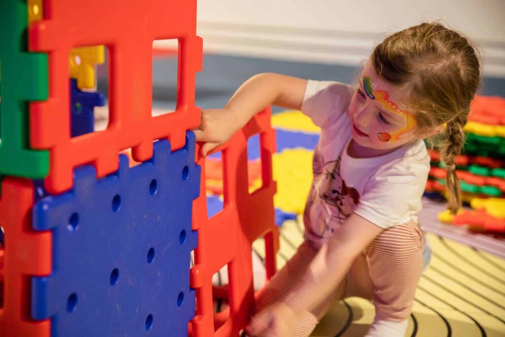 Young girl building with brightly coloured blocks in Life Science Centre's Play Zone.