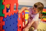 Young girl building with brightly coloured blocks in Life Science Centre's Play Zone.