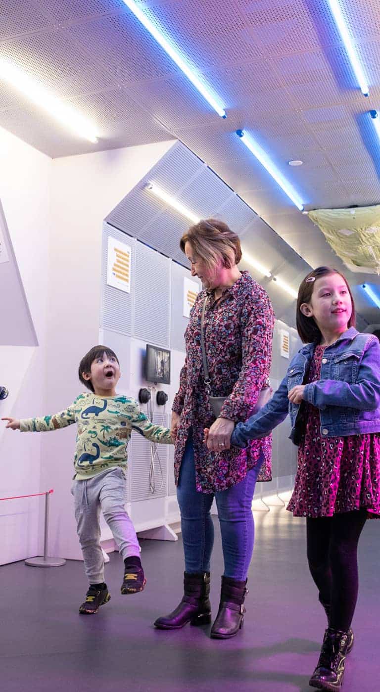 Grandmother with young children inside Life Science Centre's Internation Space Station mock-up.