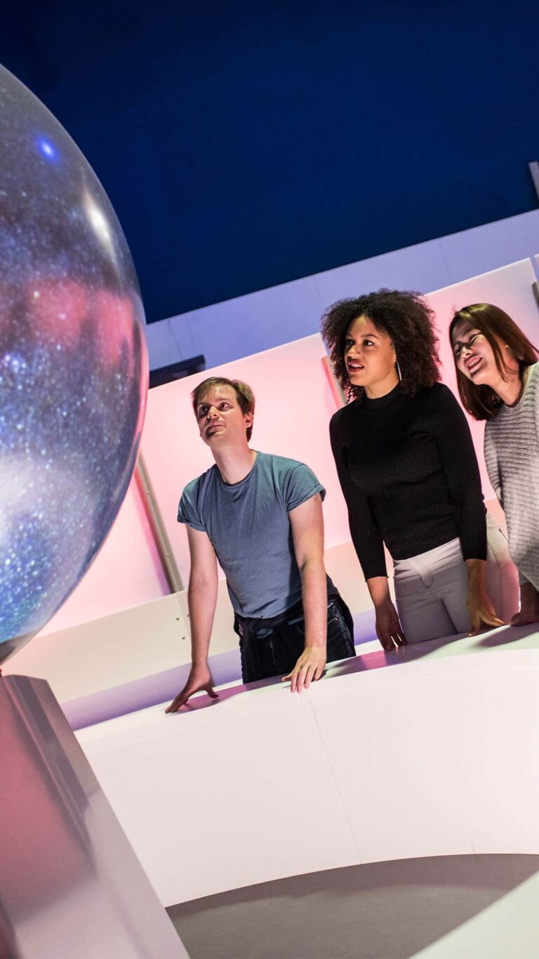 Adults watching a sphere show in Life Science Centre's Space Zone.
