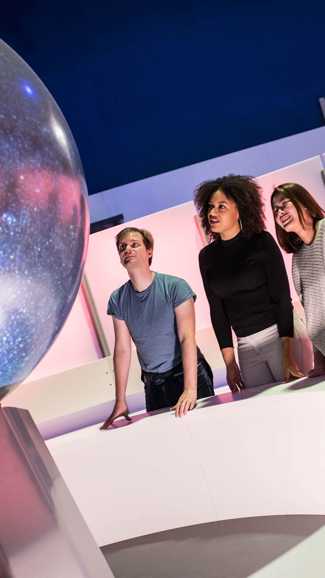 Adults watching a sphere show in Life Science Centre's Space Zone.
