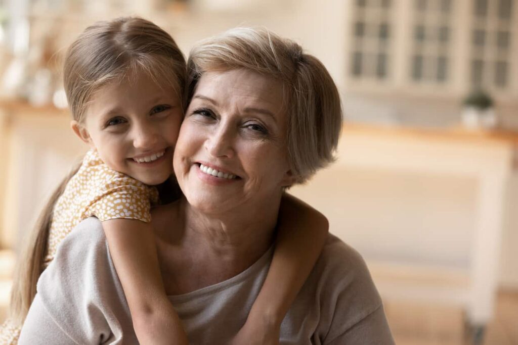 Portrait Of Happy Grandmother And Granddaughter Hugging