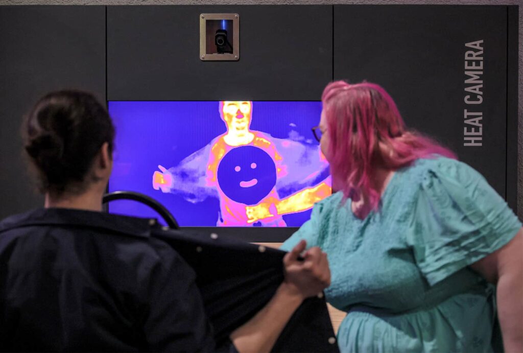 Adults using heat sensitive camera in Life's Wow Zone.