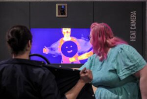 Adults using heat sensitive camera in Life's Wow Zone.
