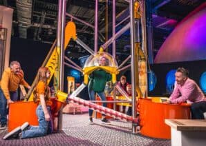 Family Playing in Life science centre Wow Zone, having hands on fun with the big machine.