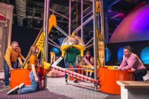 Family Playing in Life science centre Wow Zone, having hands on fun with the big machine.