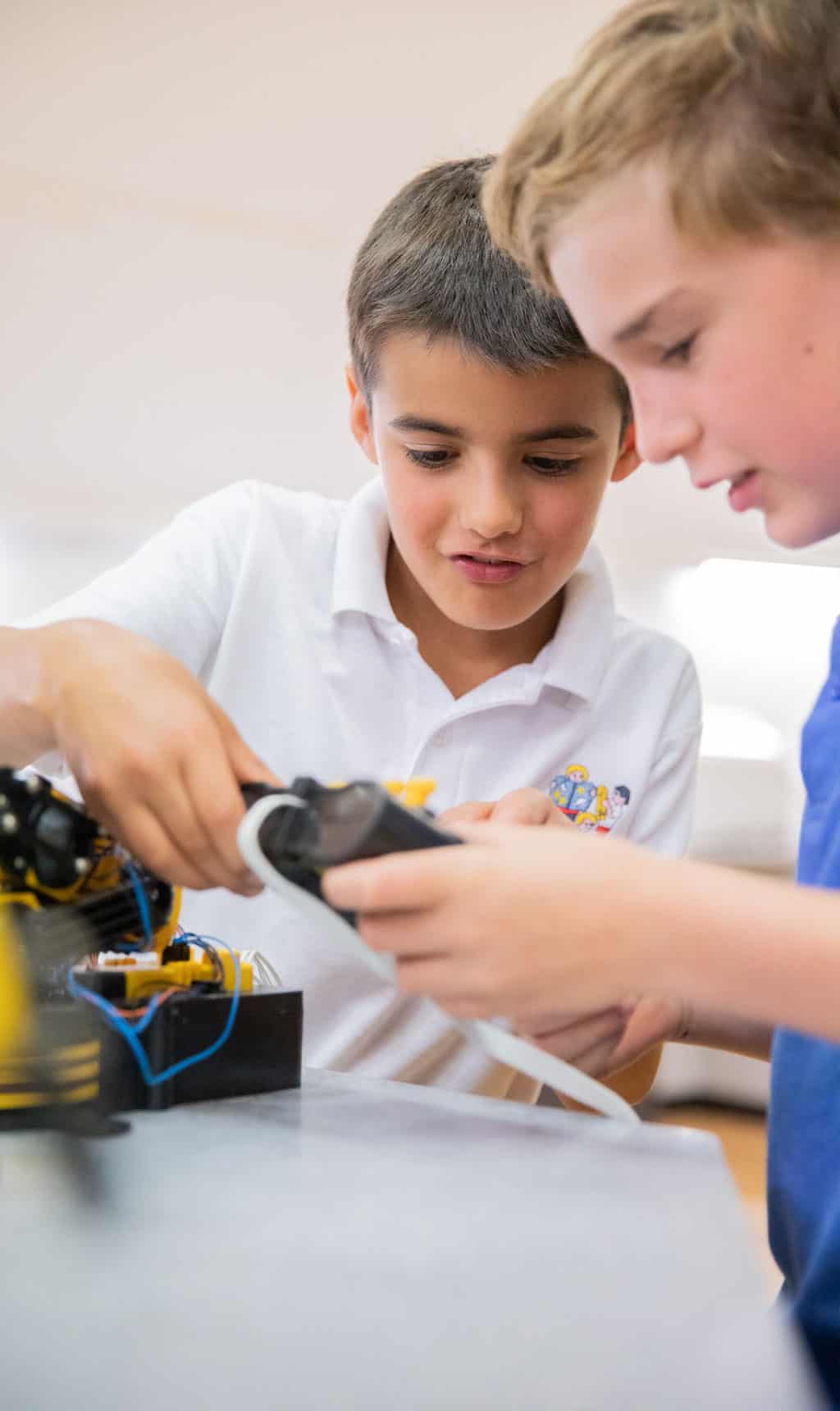 Two male school students using electronic device during Life Science Centre education workshop.