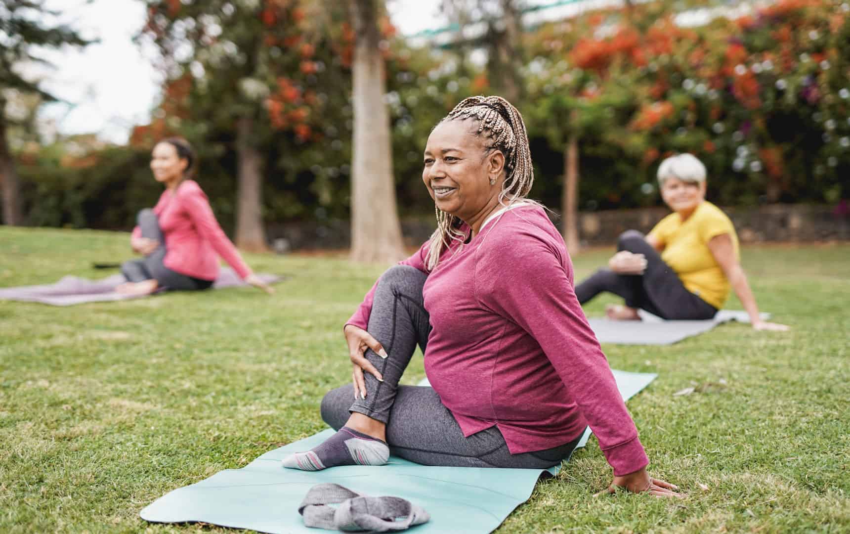 women doing yoga exercise with social distance for coronavirus outbreak at park outdoor - Healthy lifestyle and sport concept stock photo