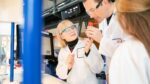 Family of three conducting an experiment using a heat detector in Life's Experiment Zone.