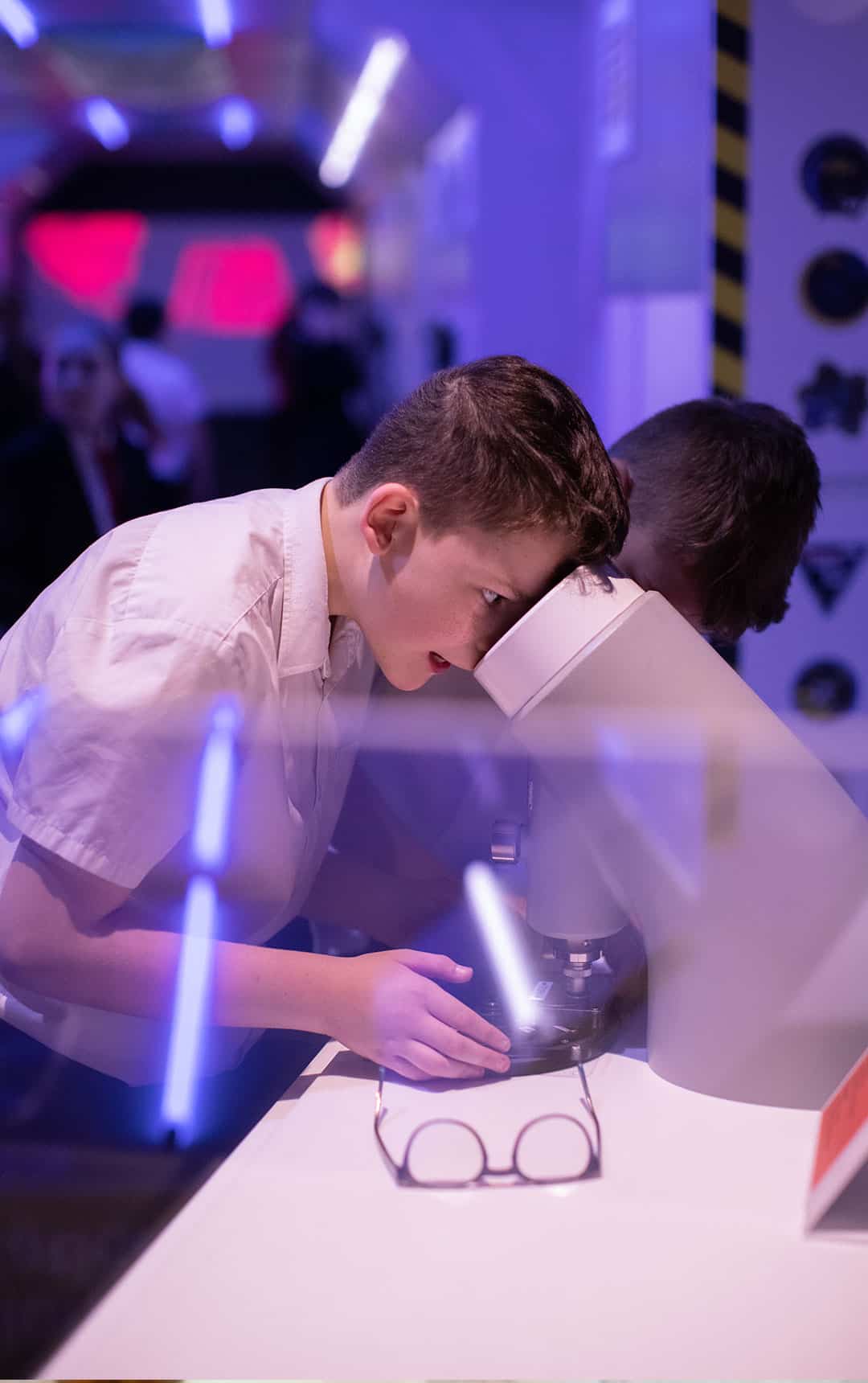 School student looking through microscope during a visit to Life's Space Zone.