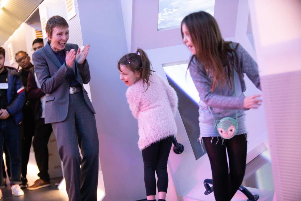 NASA Astronaut Helen Sharman pictured with two children in Life Science Centre's mock-up International Space Station.
